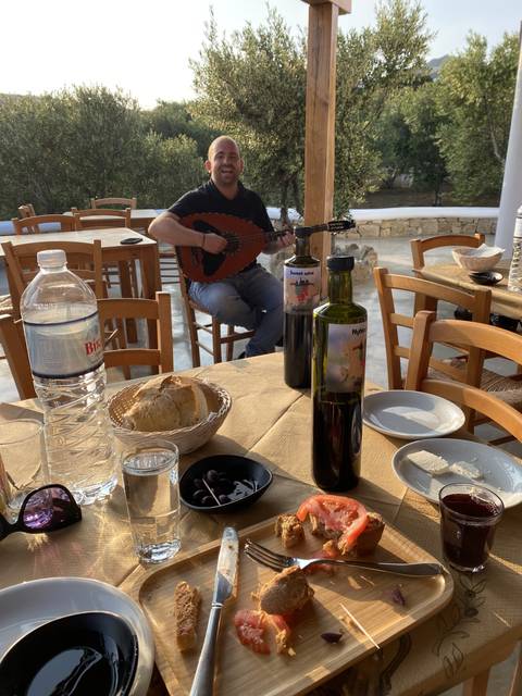       Man playing an instrument at a restaurant table.
  