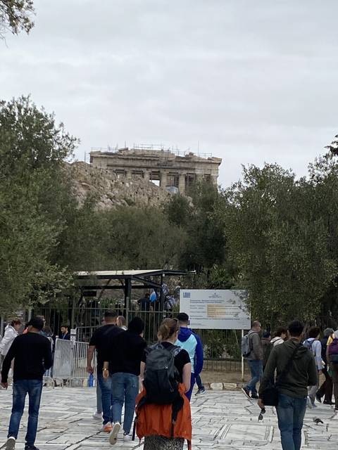       Tourists walking near a historic site.
  