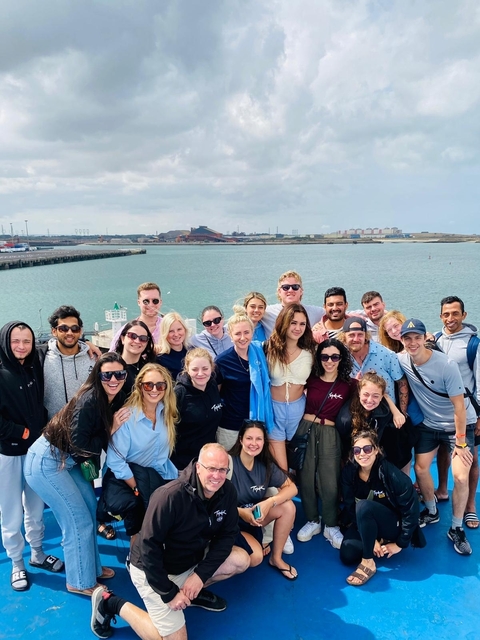 Group of people posing by the water.
