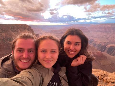       Three people taking a selfie with a canyon backdrop.
  