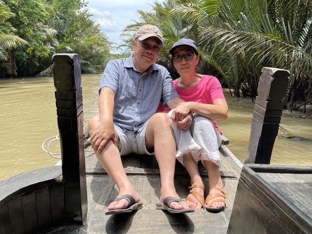 Couple seated on a boat in a tropical waterway.