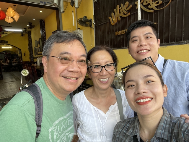 Close-up group portrait of four smiling people.