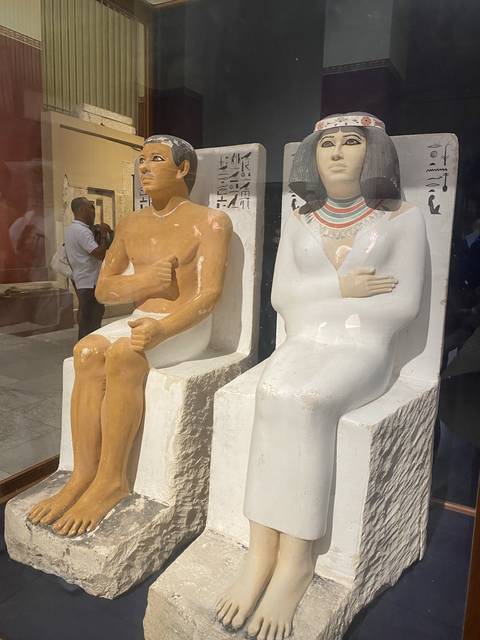 Colorful statues of seated Egyptian figures.