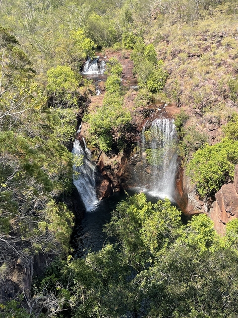 Aerial view of waterfalls surrounded by lush greenery.