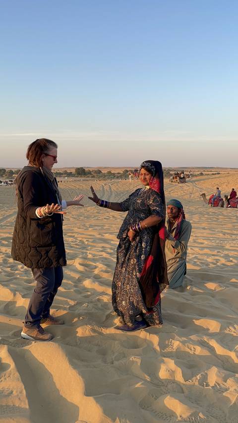 People interacting in a desert area with sand dunes.