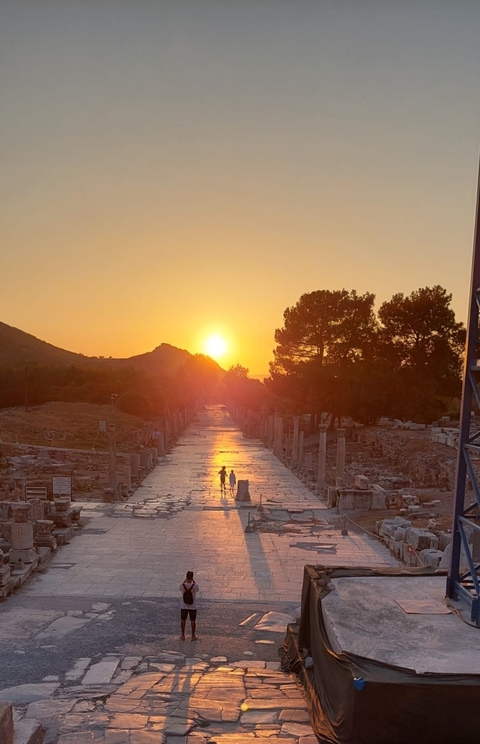 Couple walking along an ancient road at sunset.
