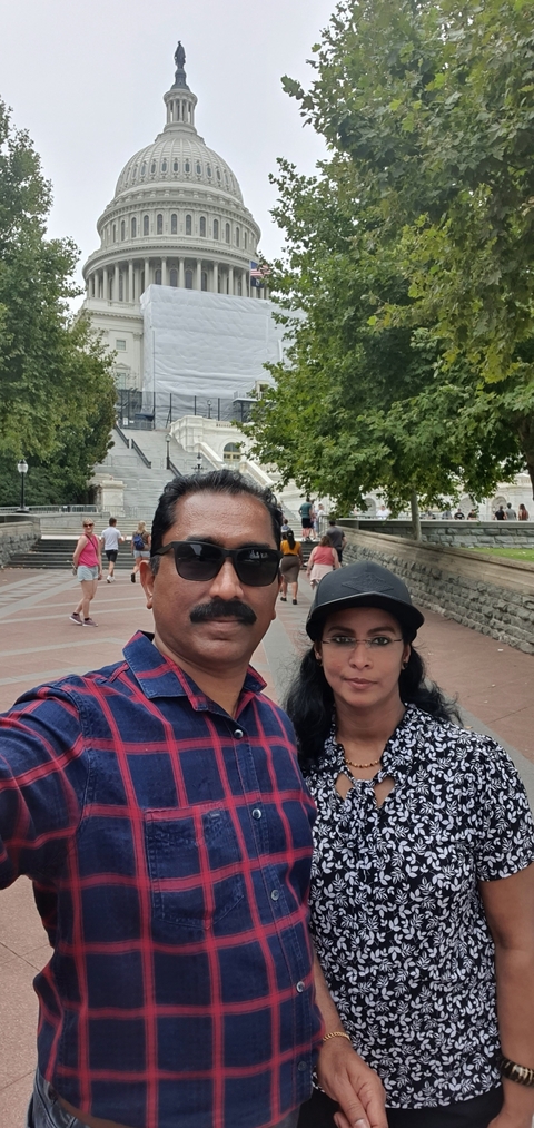       Two people posing in front of a historical building.
  