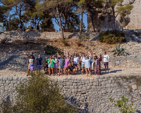 Group of people on a rocky shore posing for a photo.