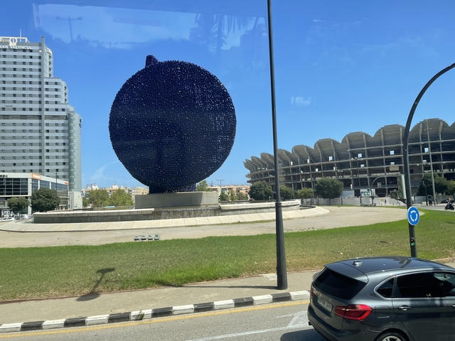 Modern sculpture and architecture in a city roundabout.