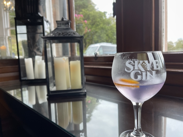 Glass of Skye gin with lanterns on a ledge.
