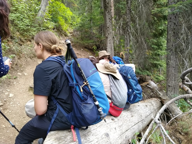       A group of hikers resting on a mountain trail.
  