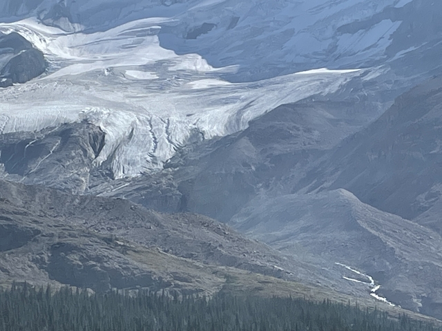 A picturesque view of a glacier with rugged mountainous terrain.