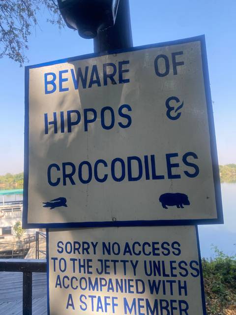 Warning sign about hippos and crocodiles.