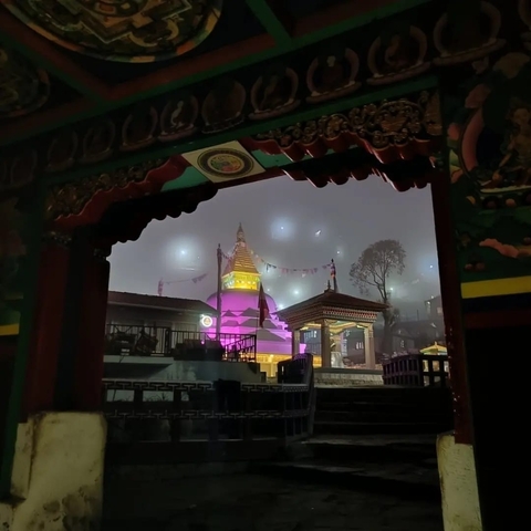       A stupa lit up in the evening with decorative detail.
  