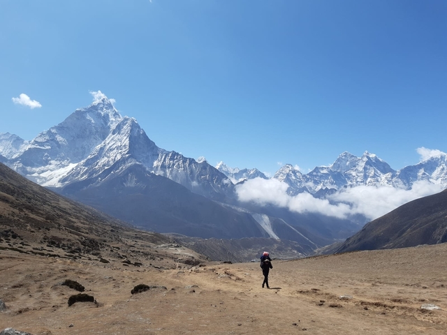       Hiker in a vast mountain landscape.
  