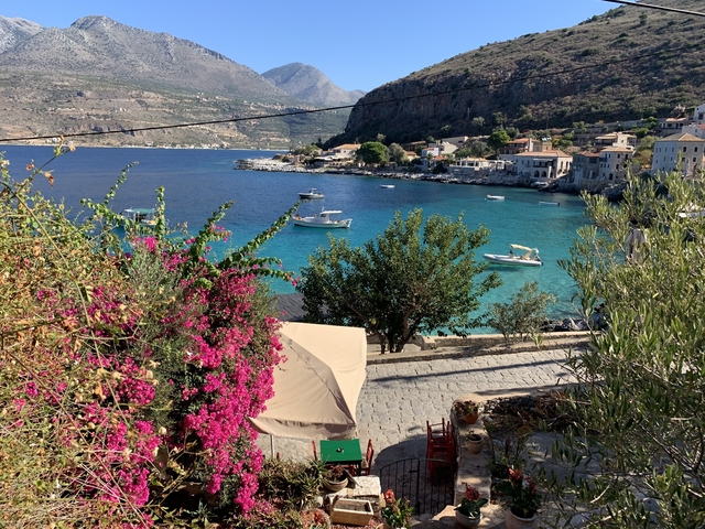       Coastal village with vibrant blue water and colorful foliage.
  