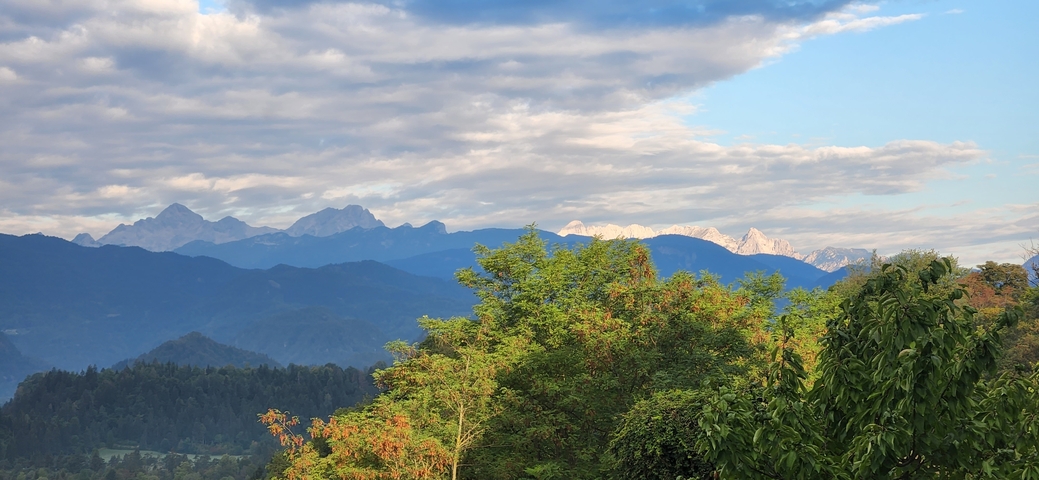       Mountain view with clouds and lush greenery.
  