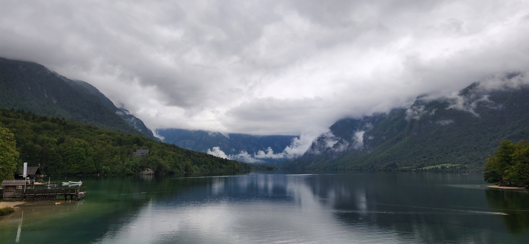       Quiet lake with mist and mountains in the background.
  