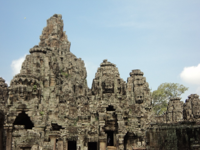 Blurry image of temple ruins with large stone faces.