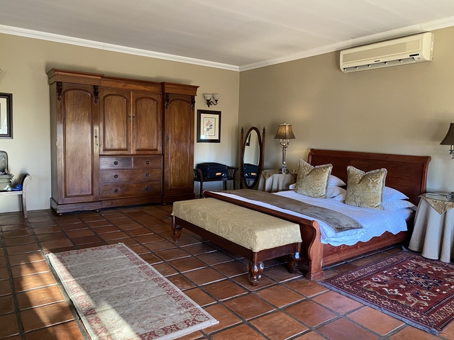 Well-furnished hotel room with wooden furniture.