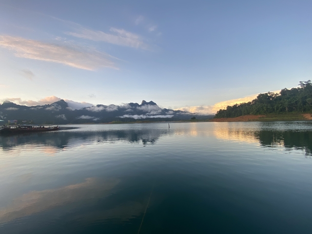 Lake with mountains in the background, reflected clouds on water.