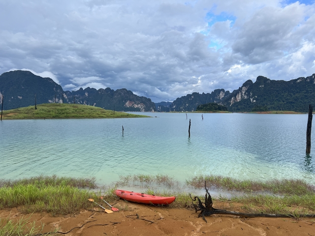 Calm lake with a kayak and mountainous landscape.