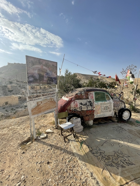       Decorated car with a sign reading 'The Smallest Hotel in the World'.
  