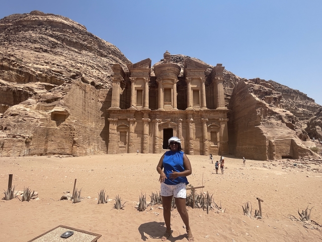       Woman posing in front of the Monastery in Petra.
  