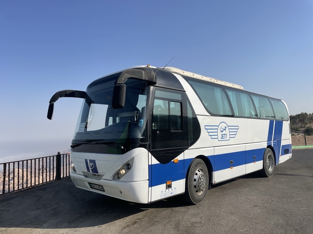       Tour bus parked with scenic background.
  