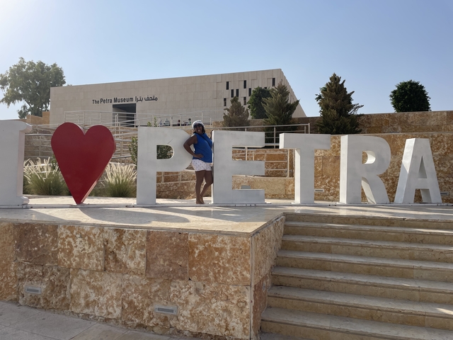       Woman posing in front of 'I Love Petra' sign.
  