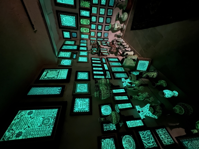       Wall with glowing green framed patterns and vases.
  