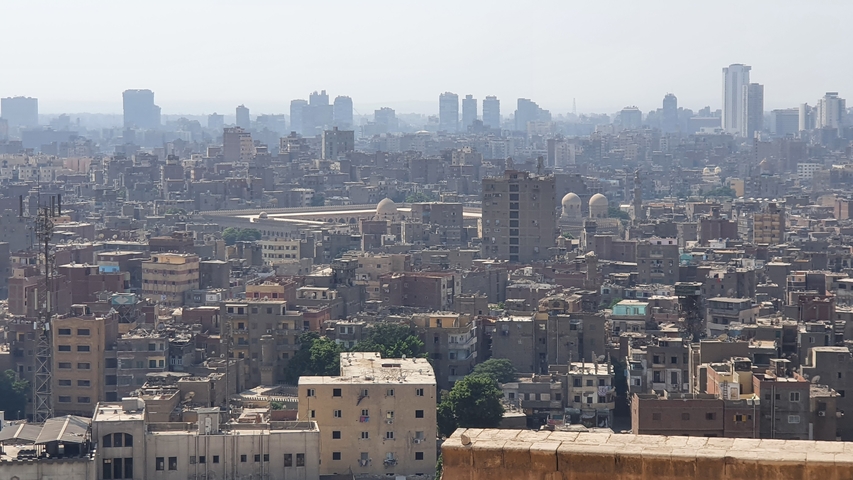 Panoramic view of a dense urban cityscape with distant buildings.