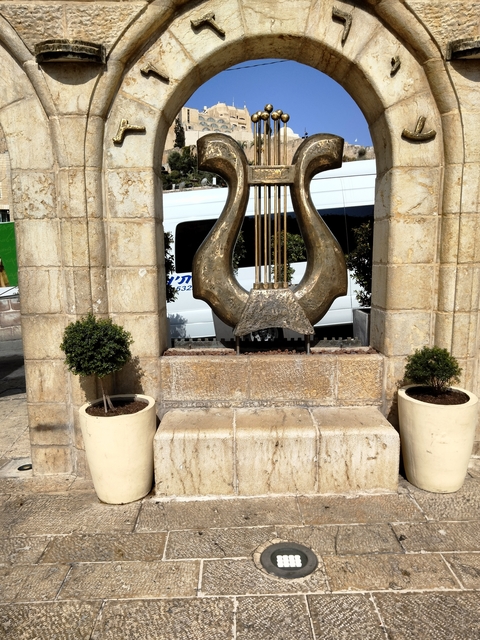 Bronze harp sculpture on a stone base.