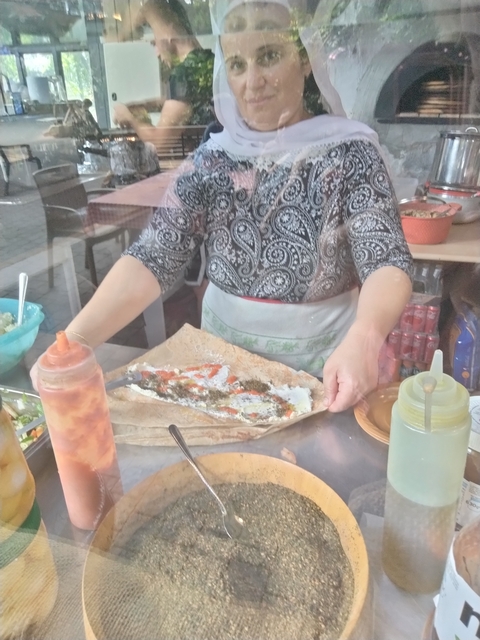Person preparing traditional food at a stall.