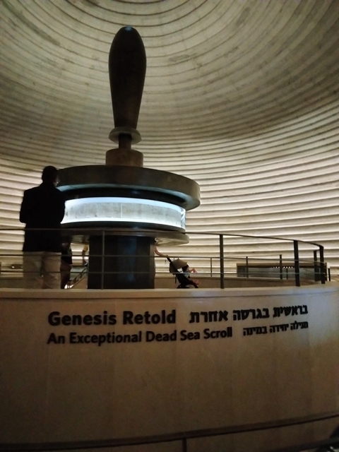       Museum interior with a display and people observing.
  