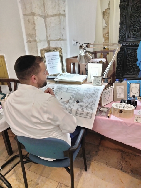 A man working on traditional scroll art.