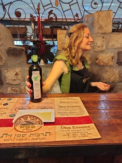       Person holding a bottle of olive oil.
  