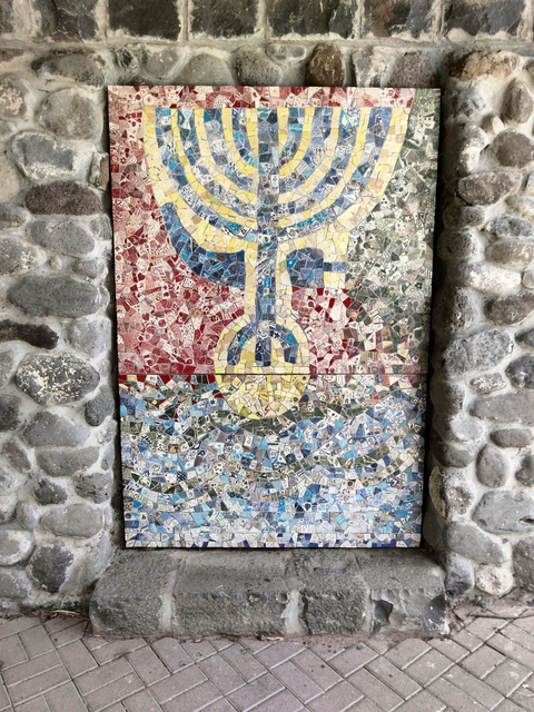       Colorful mosaic artwork with a cultural symbol.
  
