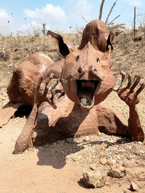       Large metal sculpture of an animal outdoors.
  