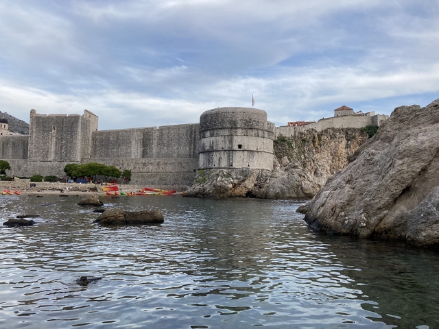 Historic fortifications by the sea with a rocky landscape.