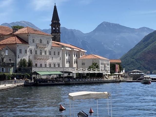 Picturesque waterfront architecture with mountain backdrop.