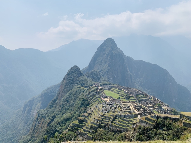 Iconic ruins on a mountain with misty hills.