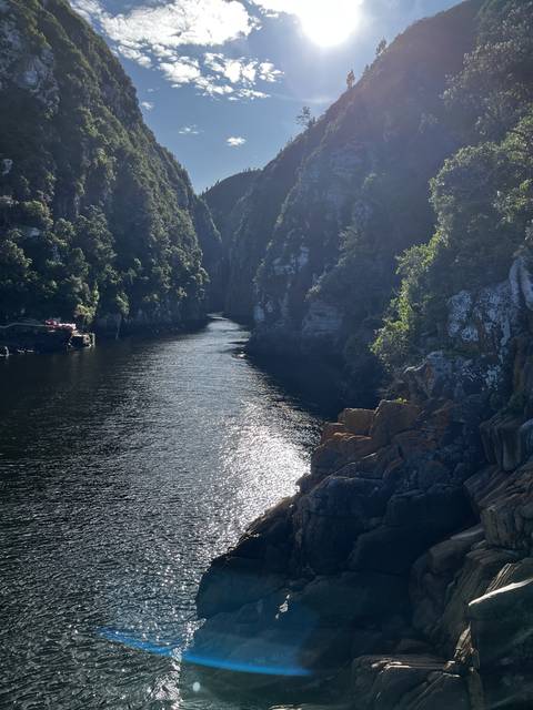 Mountainous landscape with a sunlit waterway.