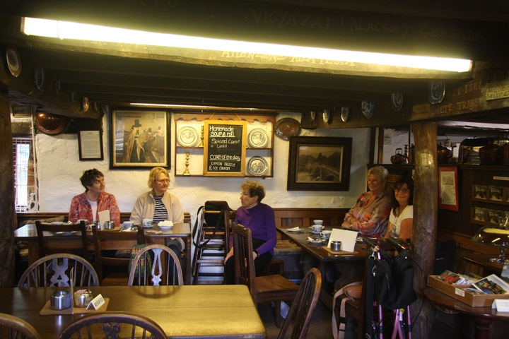 Group of people sitting inside a cozy, rustic cafe.