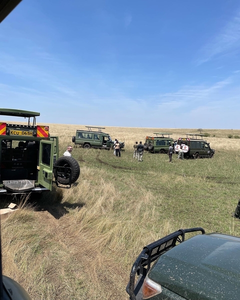       Safari jeep and tourists on a grassland
  