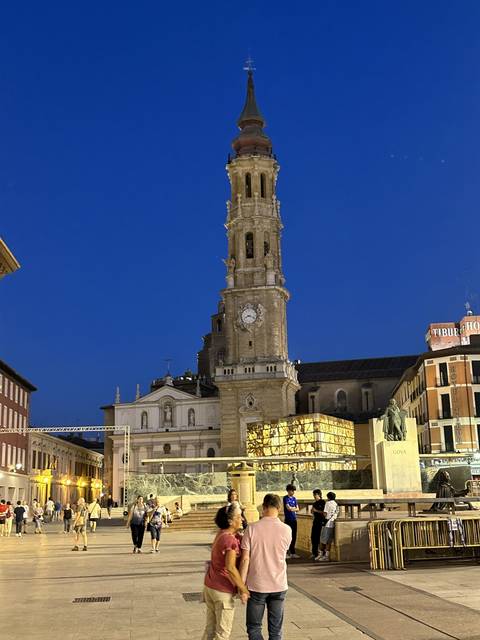 Tall clock tower lit up against the night sky.