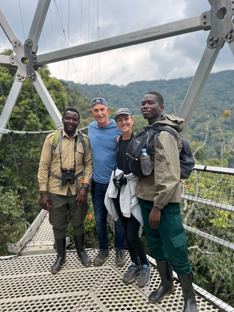 Group of people on a suspension bridge in a forest.