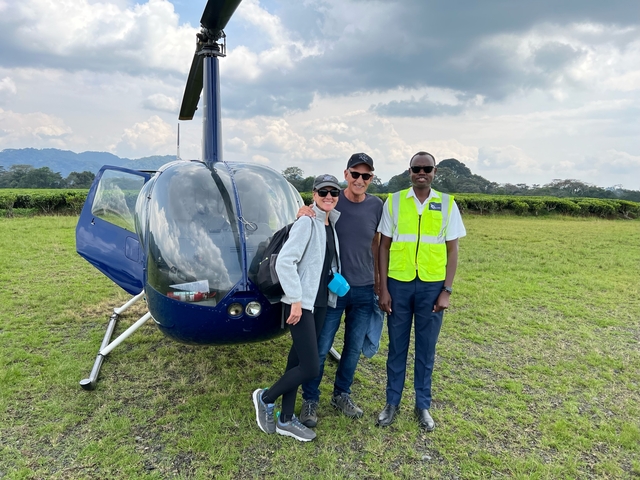 Helicopter with people posing in front of it.