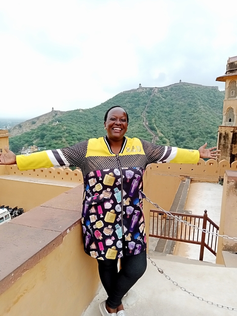 Cheerful woman on a balcony overlooking hills.