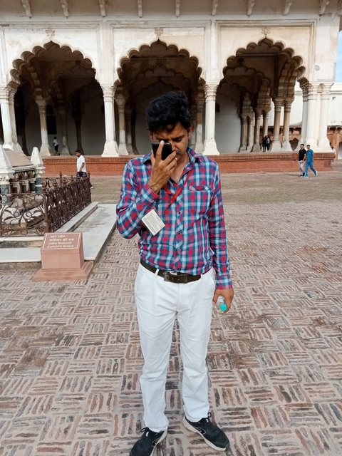 Man talking on the phone in a courtyard.